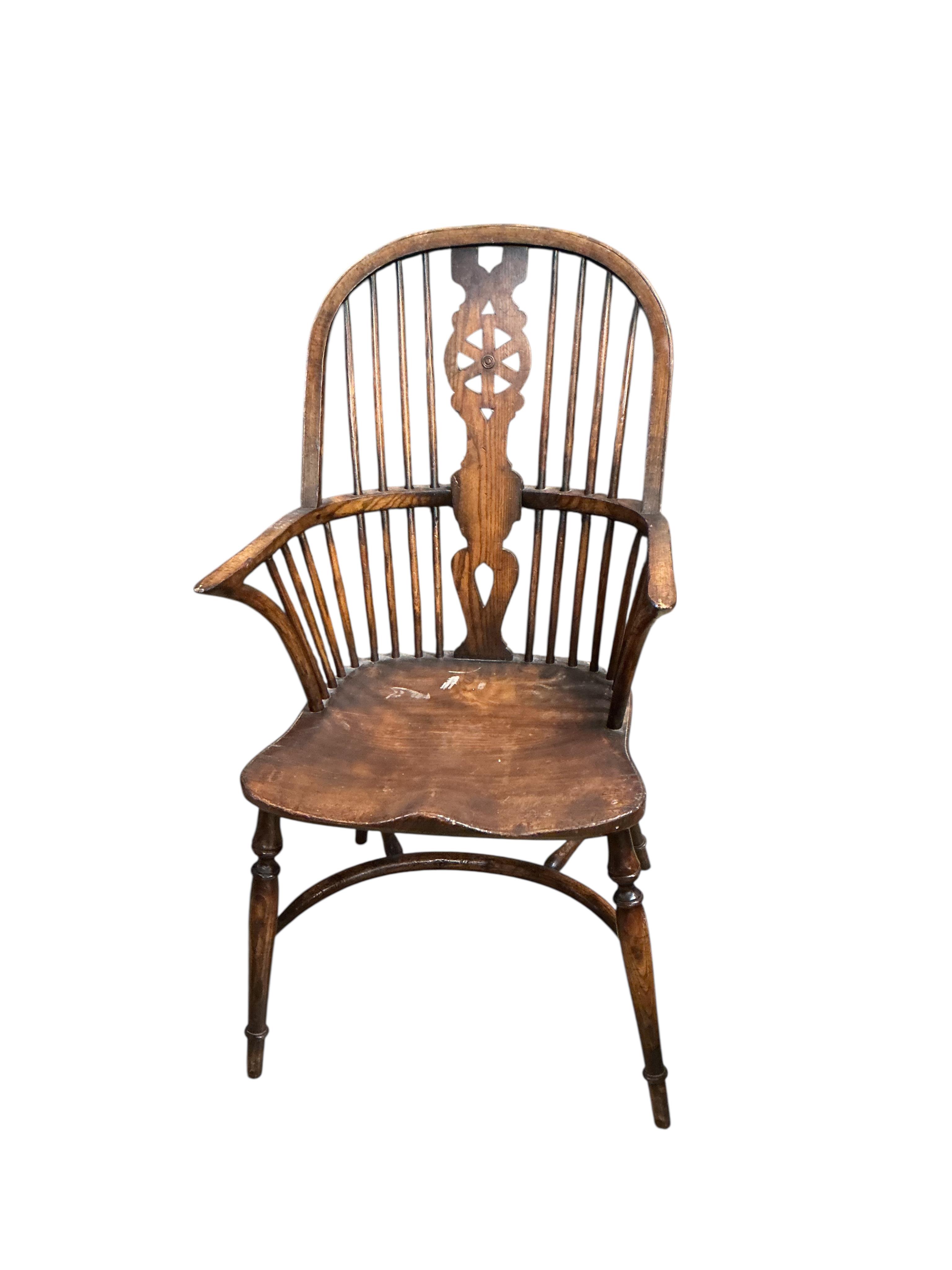 A set of ten reproduction Windsor elm and beech dining chairs with pierced splats and crinoline stretchers, two with arms